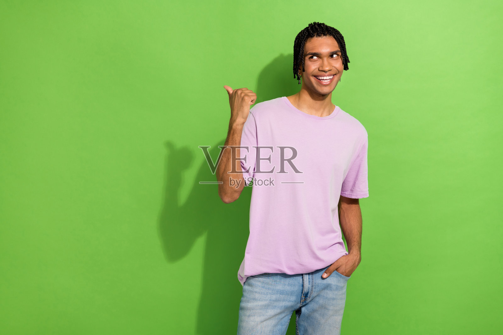 开朗的人笑容灿烂的肖像直视拇指手指空白的空间孤立在绿色的背景照片摄影图片