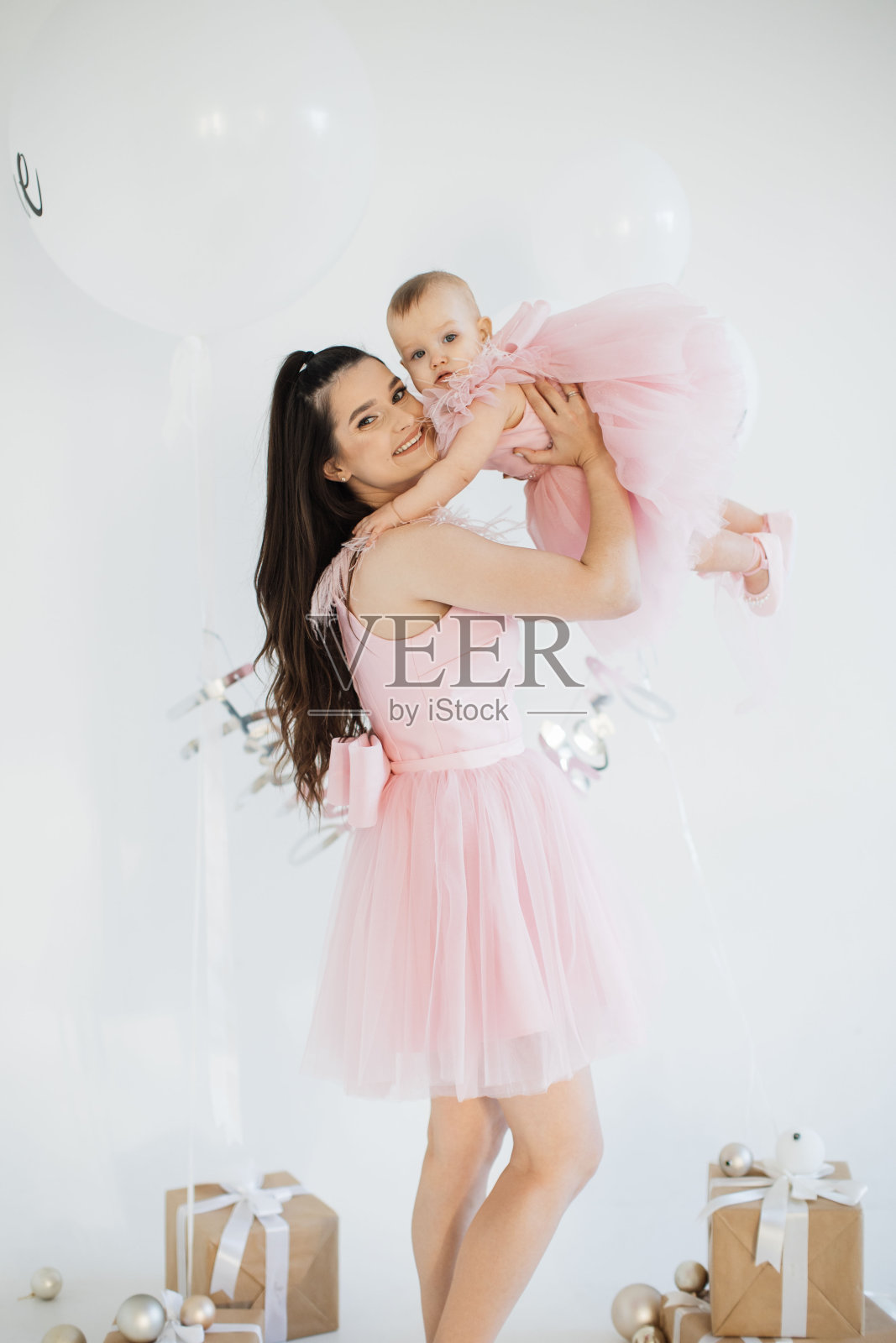 妈妈抱着小寿星在装饰精美的画室里照片摄影图片