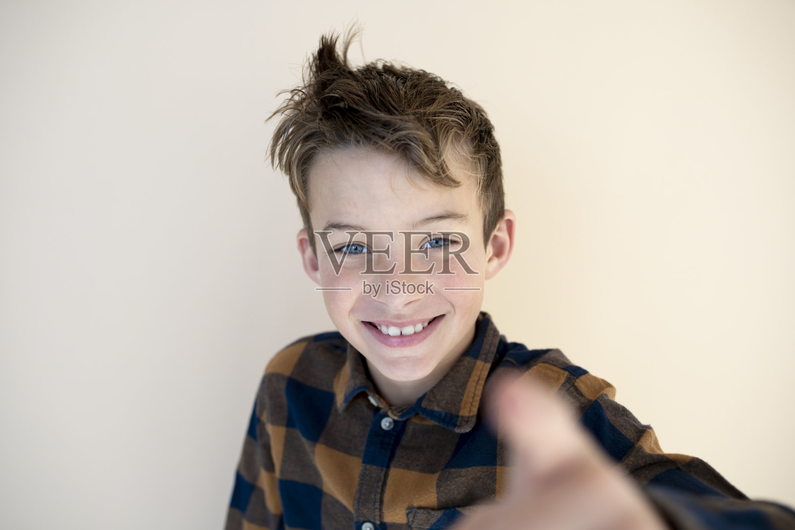 很酷的小男孩站在棕色背景前照片摄影图片