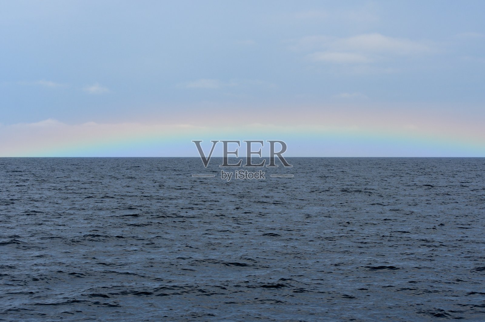 一道彩虹出现在北海道知子半岛劳苏海岸的地平线上。照片摄影图片