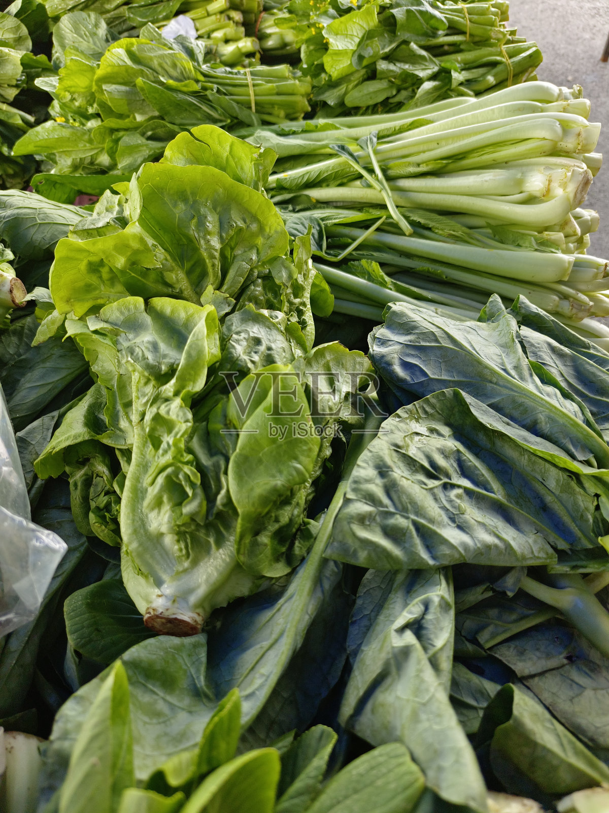 早市出售的绿色蔬菜的散焦视图照片摄影图片