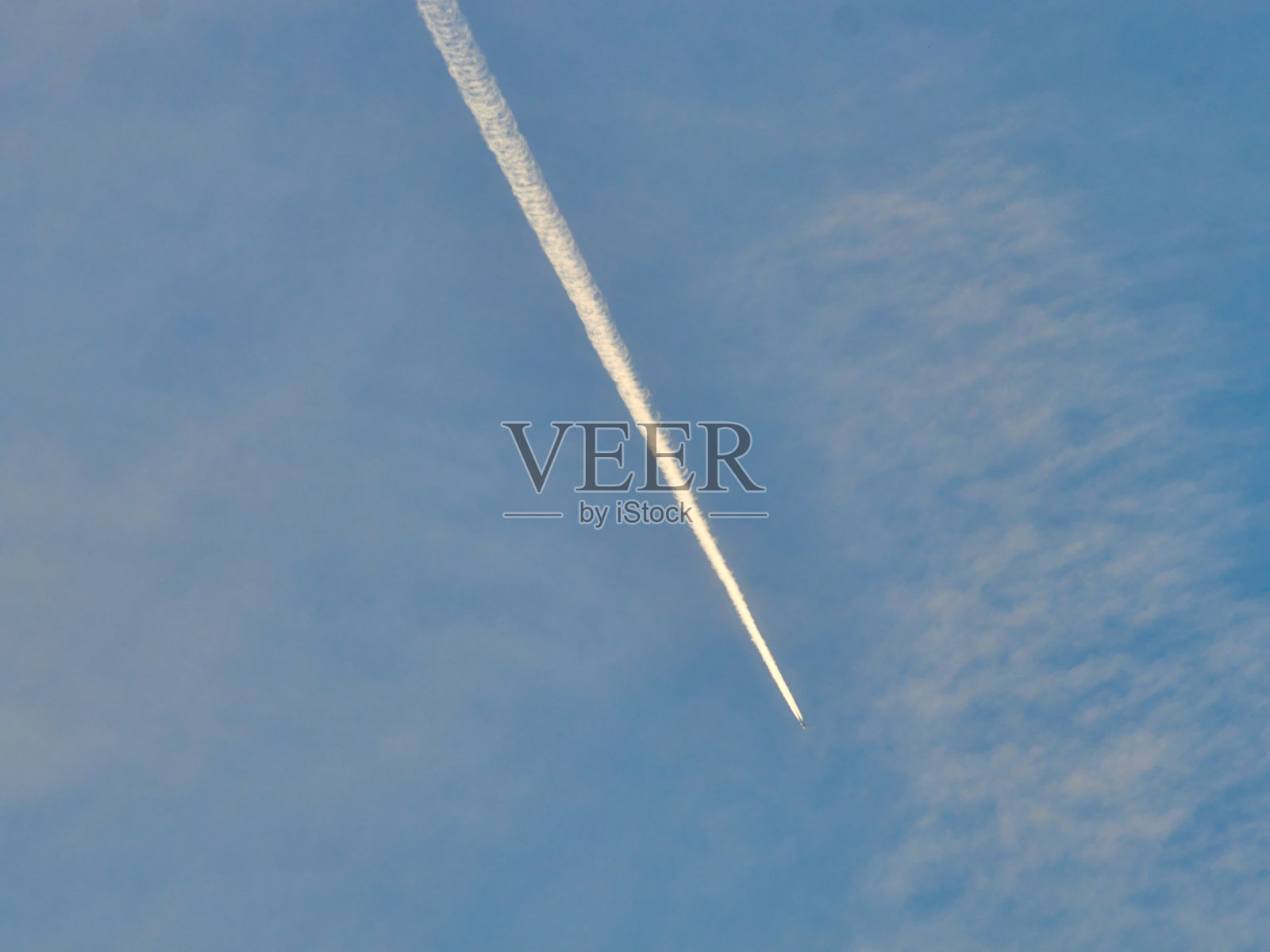 日落时飞机在蓝天上飞行。照片摄影图片