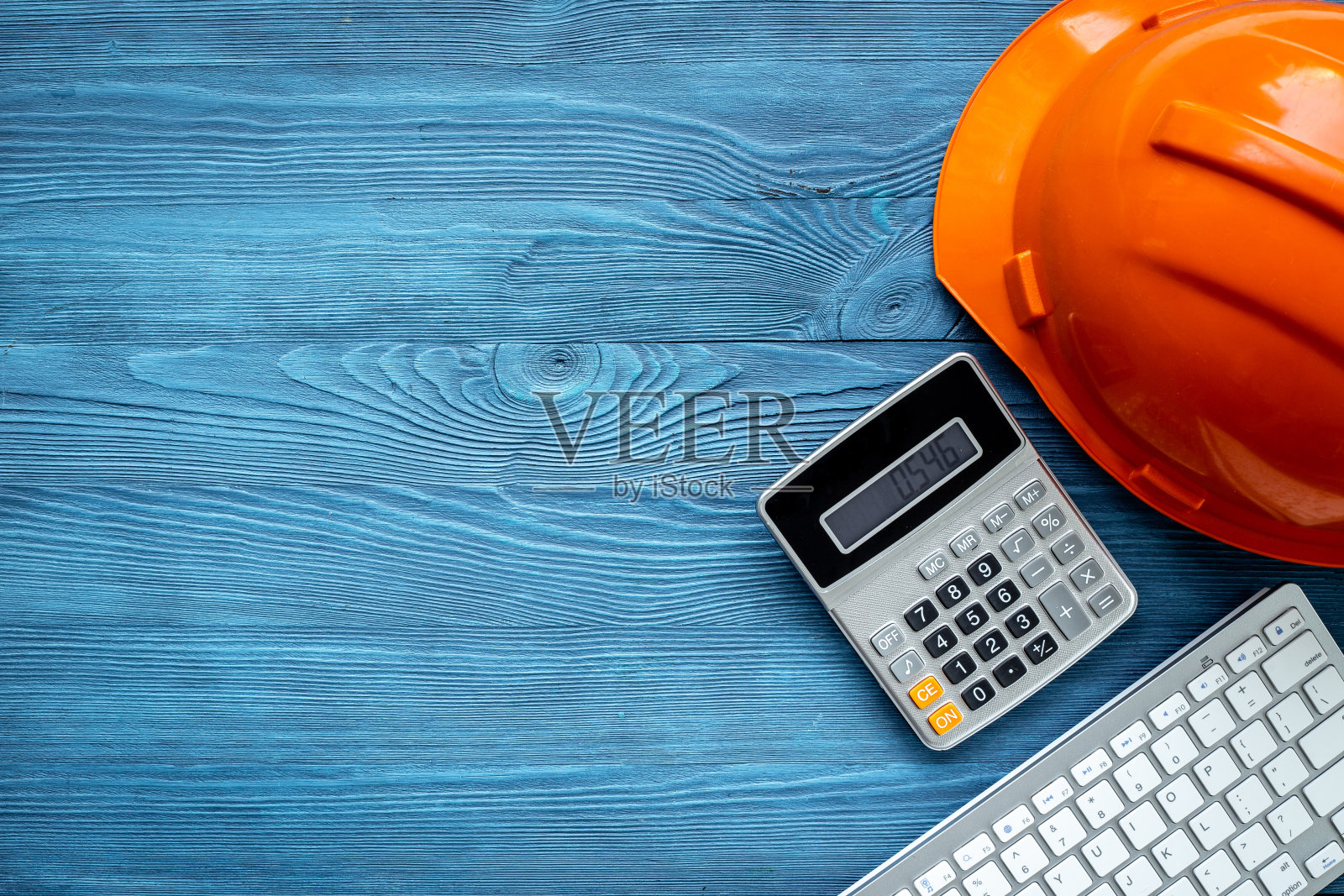 建筑师办公桌与计算器和施工头盔，俯视图照片摄影图片