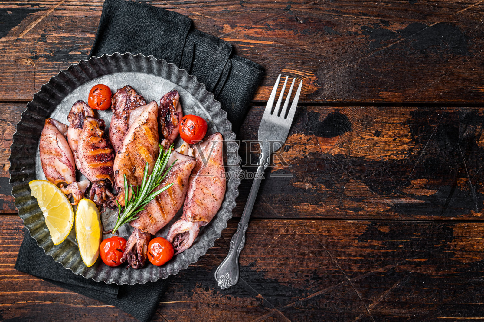 烤鱿鱼，鱿鱼和香草。木制背景。前视图。本空间照片摄影图片