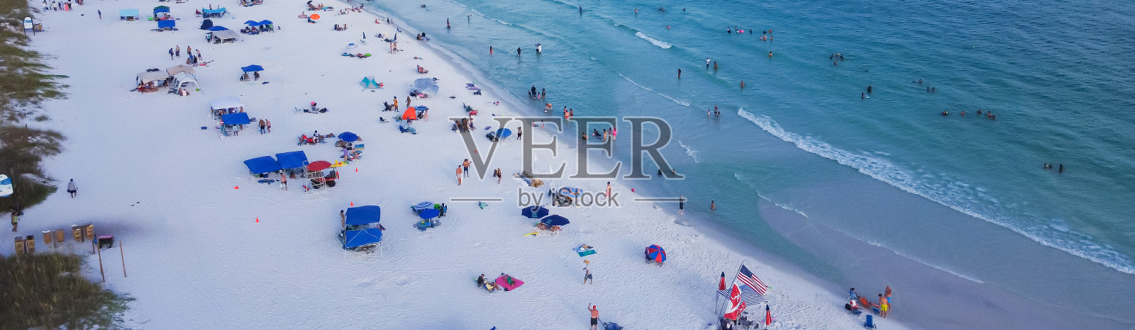 在美国佛罗里达州德斯汀的南沃尔顿海滩，绿松石般的海水，糖白色的沙滩海岸线上，各种各样的人群游泳，放松，五颜六色的帐篷，天篷，躺椅照片摄影图片