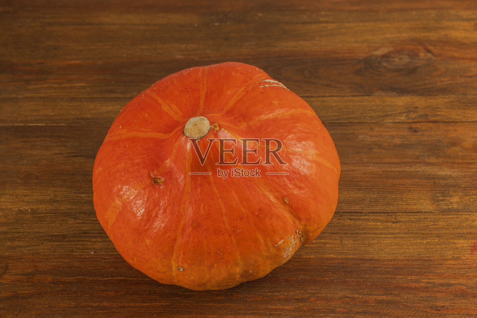 木制背景上的红南瓜特写。照片摄影图片