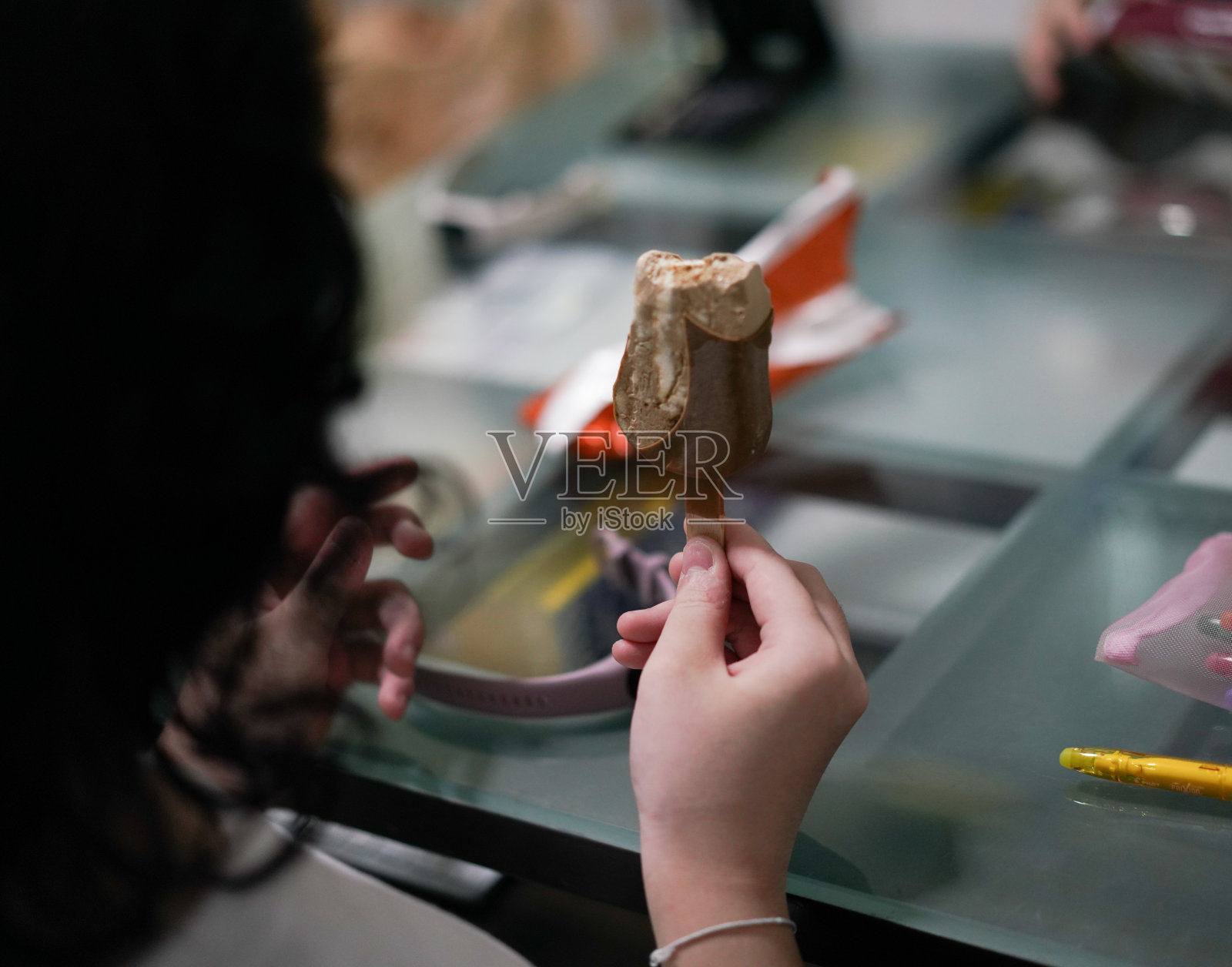 小女孩在家里的餐桌上尽情地吃着冰激凌。照片摄影图片
