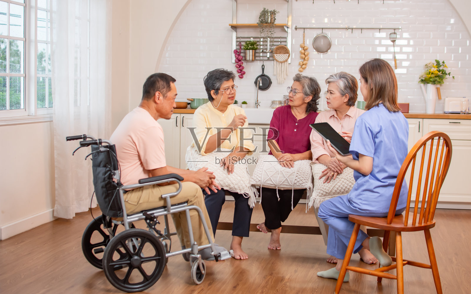 一群快乐的老人，医生一起在社区聊天，咨询心理健康，微笑着幸福，坐在室内养老院。退休，医疗保健概念。照片摄影图片