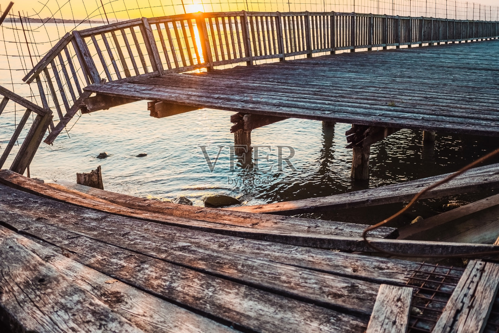 一条古老的木栈道通往湖中，栈道上的木板已被岁月磨损。照片摄影图片