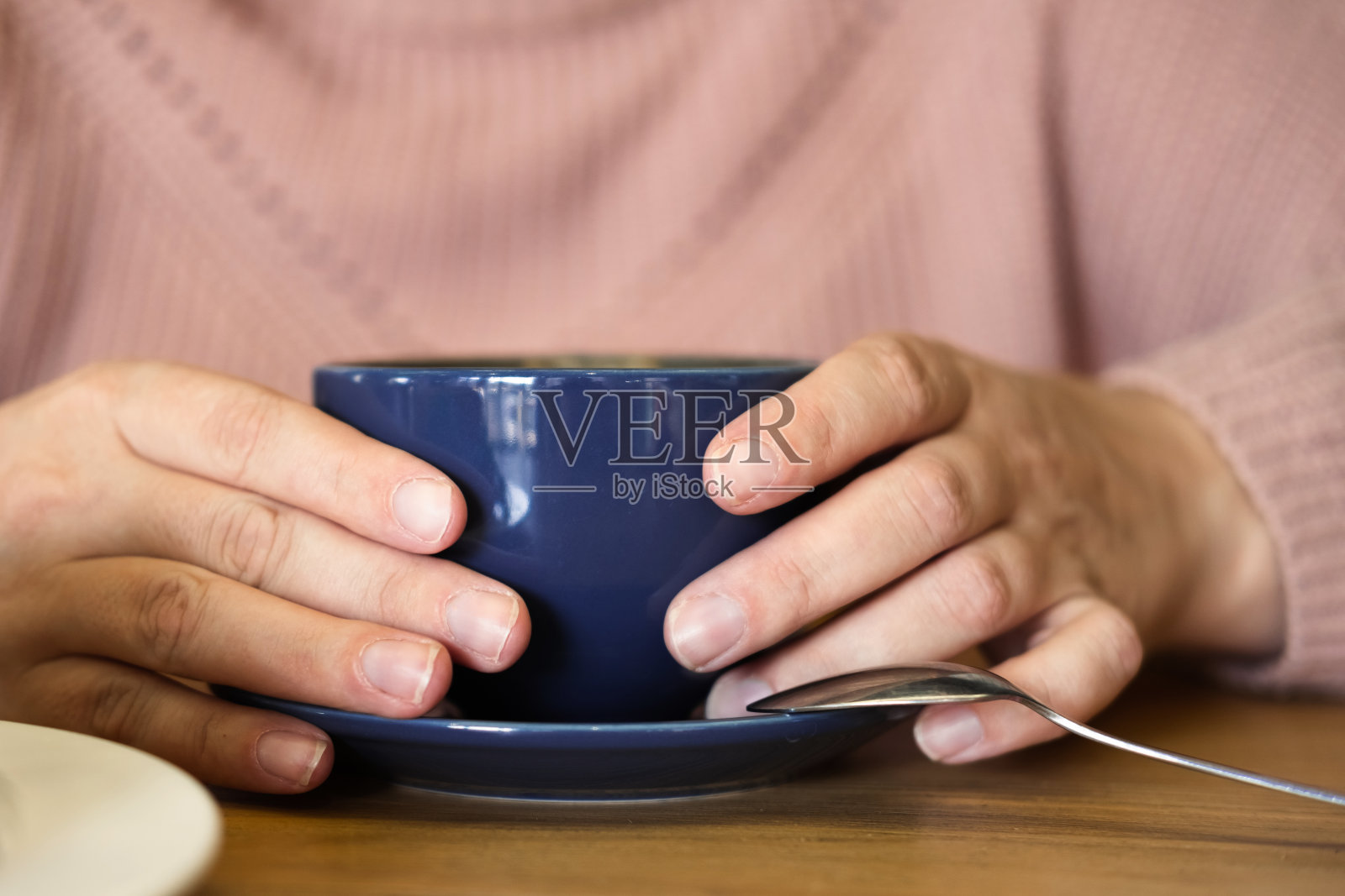 咖啡杯。软的焦点。女士的手捧着卡布奇诺。不知名的女人穿着温暖的针织毛衣，拿着蓝色的拿铁杯。关闭了。裁剪。未被认出的女性。巨大的冬季心情照片摄影图片