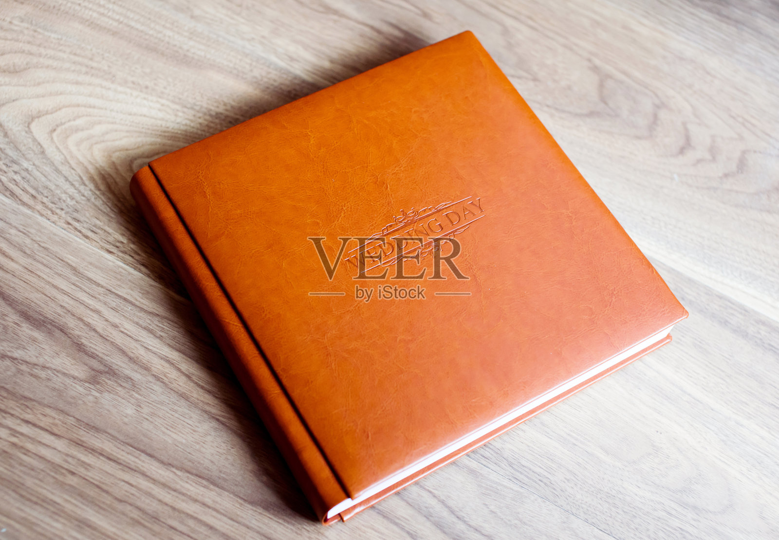 婚礼照片集在皮革封面与压花躺在桌子上照片摄影图片