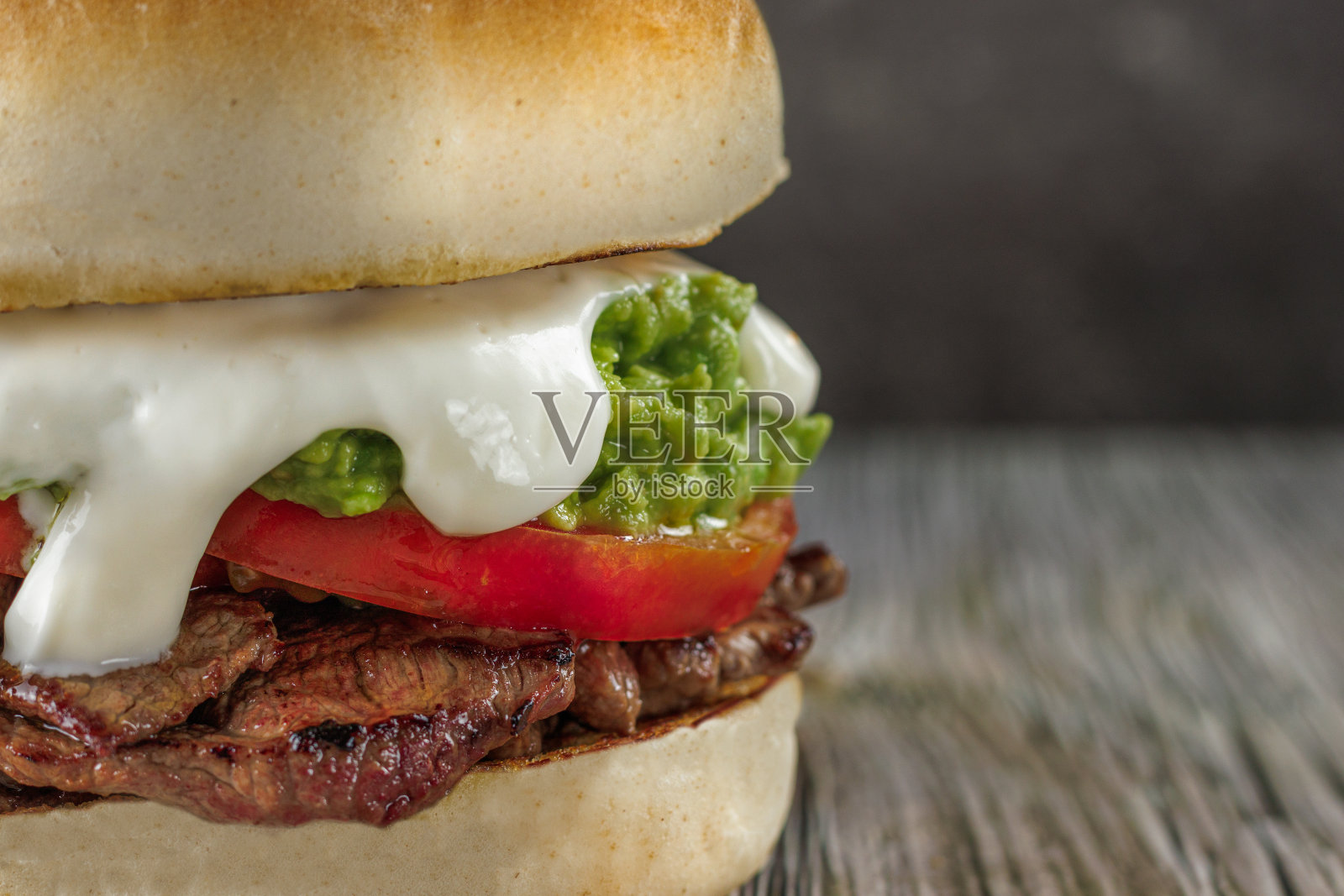 智利流行的意大利烤肉三明治，圆形面包，牛肉，番茄和牛油果在木桌上。留白。典型的智利美食概念照片摄影图片