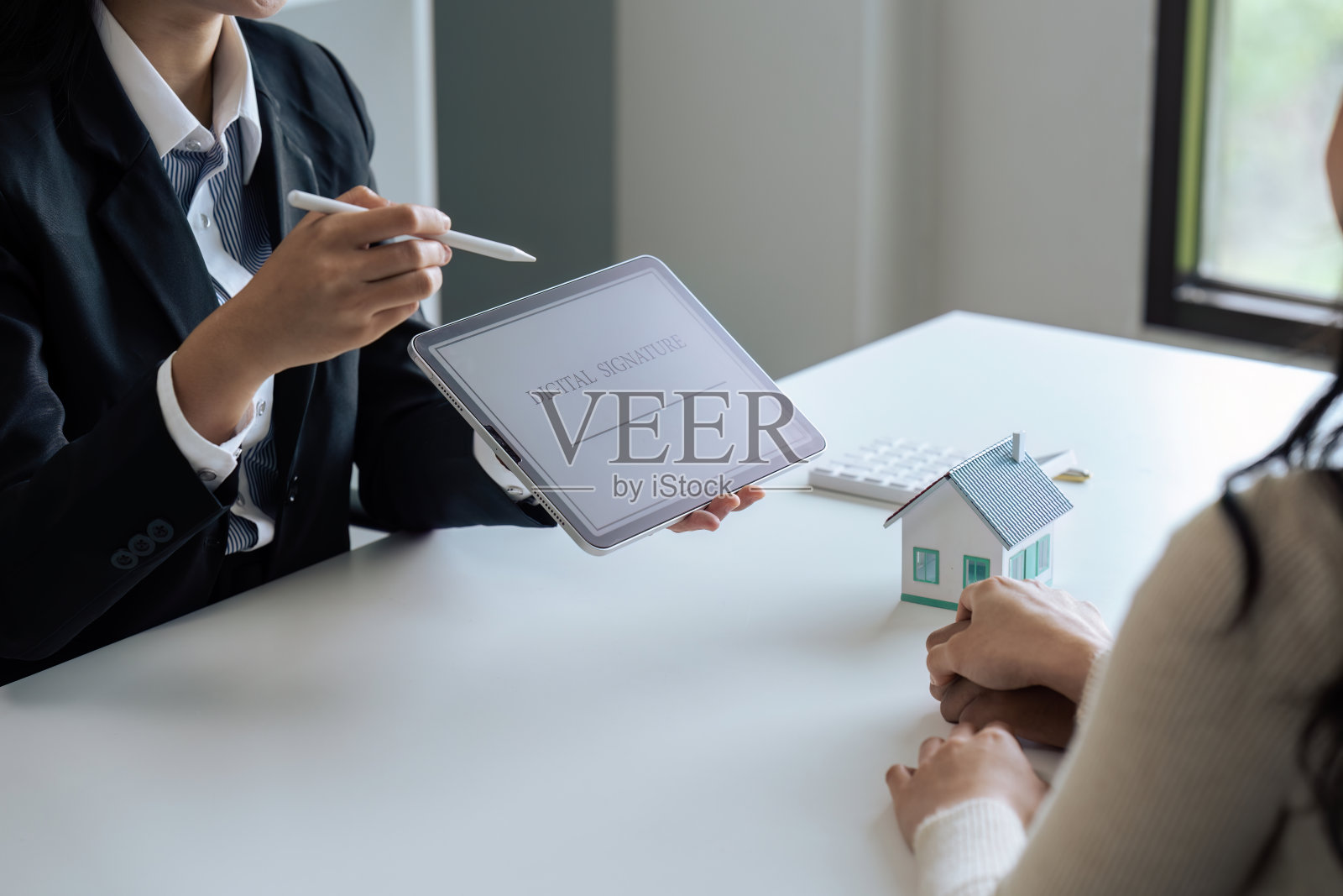 房地产中介正在讲解如何使用网上签名签署购房合同。登录平板电脑照片摄影图片