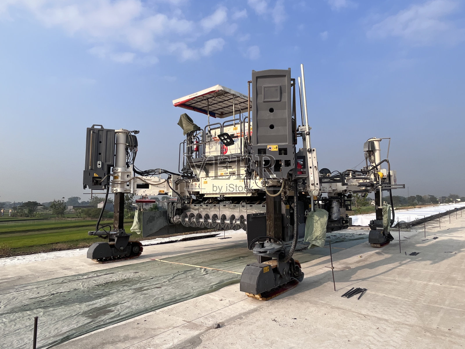 在建筑工地进行道路工作的滑模摊铺机。新城区公路混凝土铺装。使用新技术修复混凝土道路。机照片摄影图片