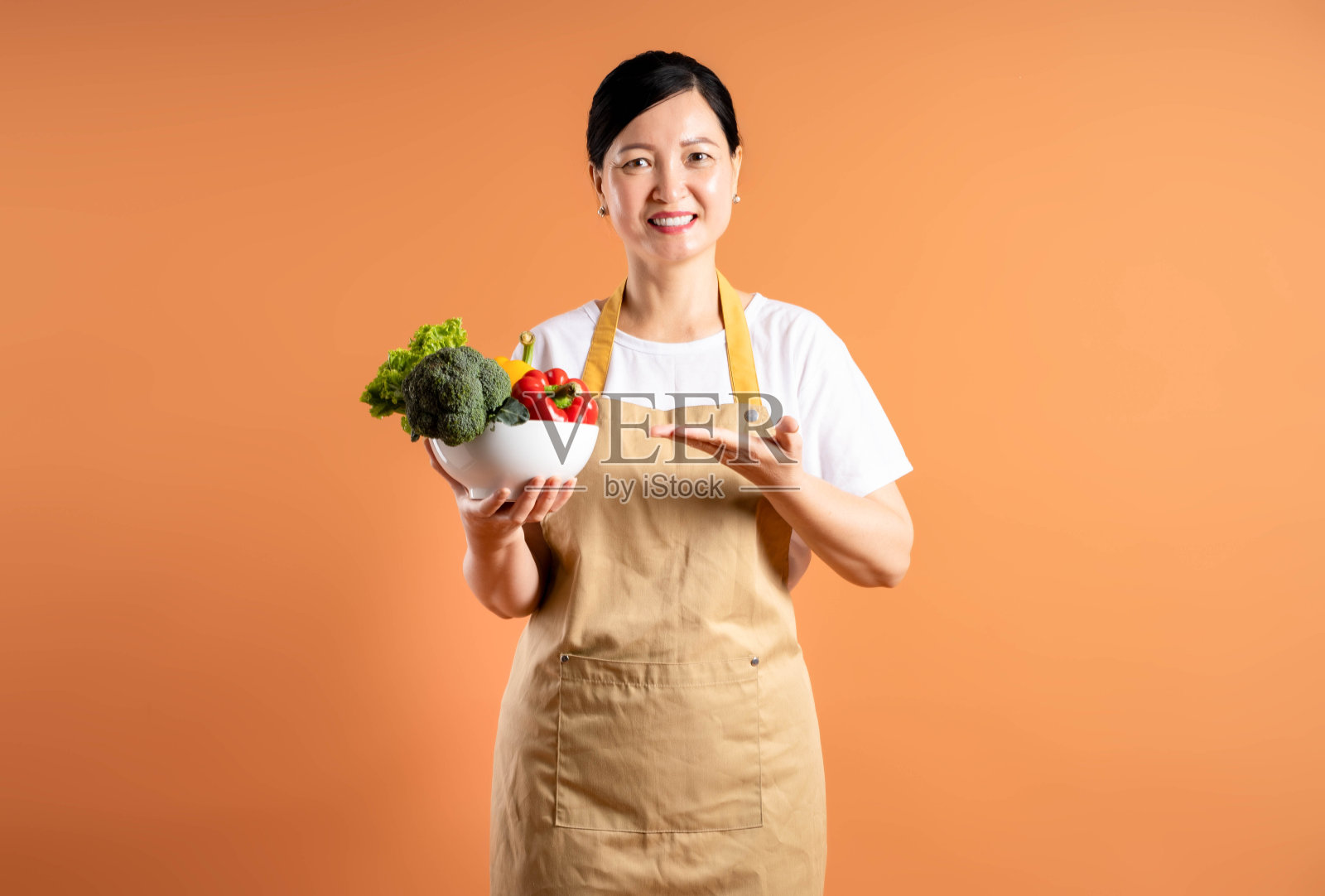 亚洲女性家庭主妇在棕色背景上摆姿势的肖像照片摄影图片