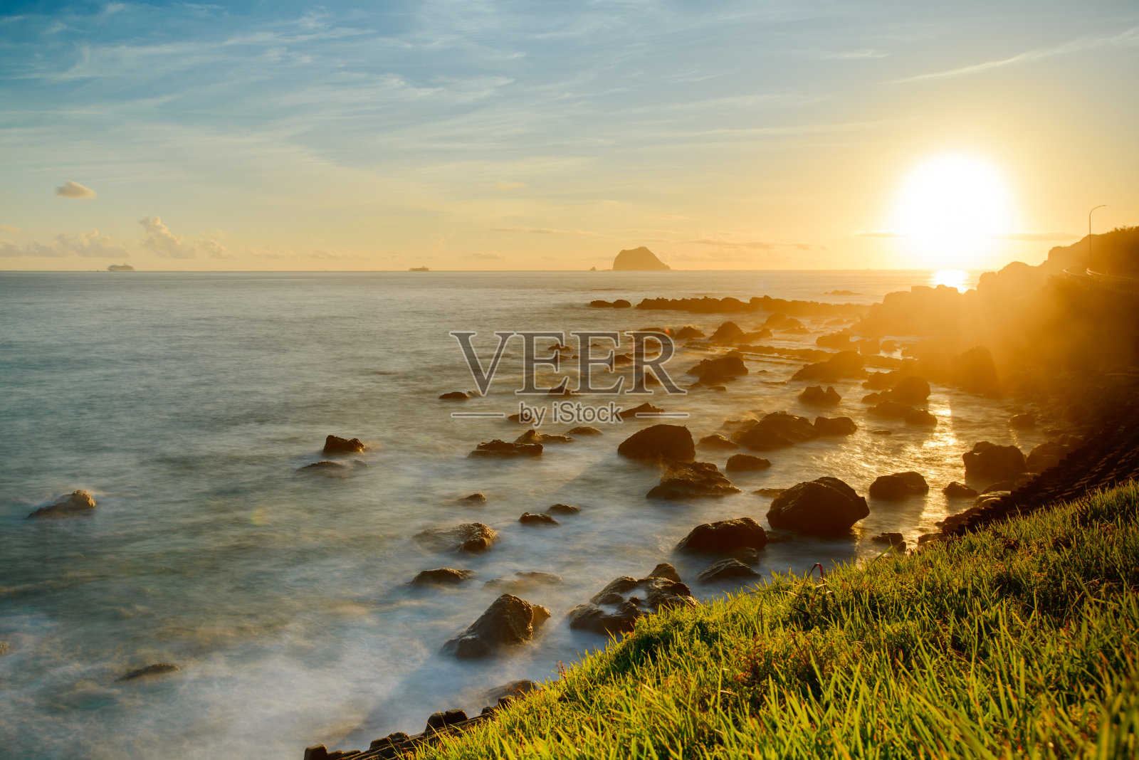 冉冉升起的太阳的光辉:海滨日出和岩石宁静。照片摄影图片