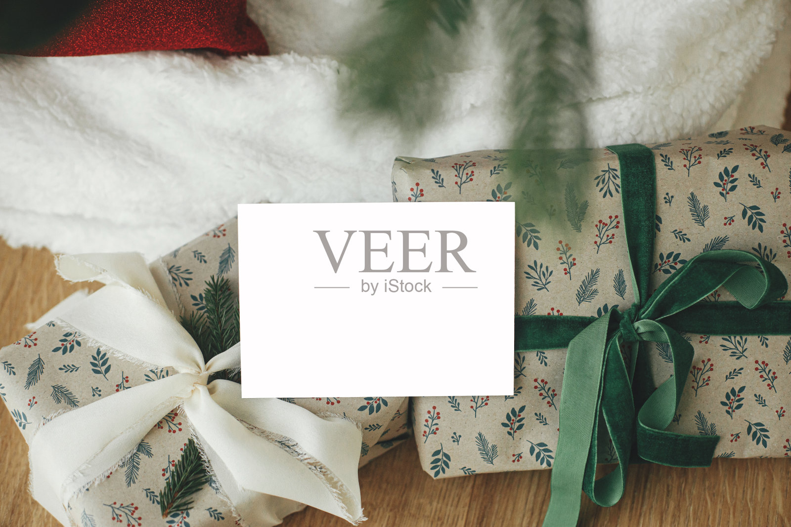 圣诞贺卡模型。空贺卡的背景是时尚包装的圣诞礼物，在节日的圣诞树下与金色的灯。文本空间。节日问候模板照片摄影图片