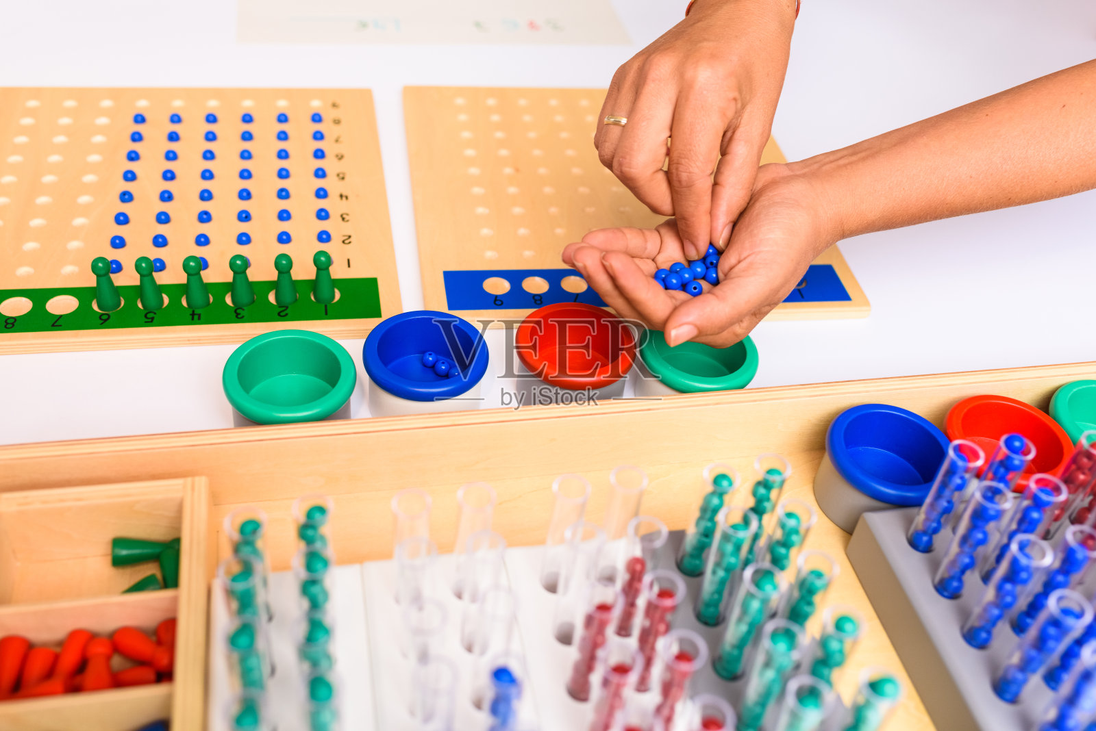 蒙台梭利板分割的细节与指导和老师的手展示如何执行操作。照片摄影图片