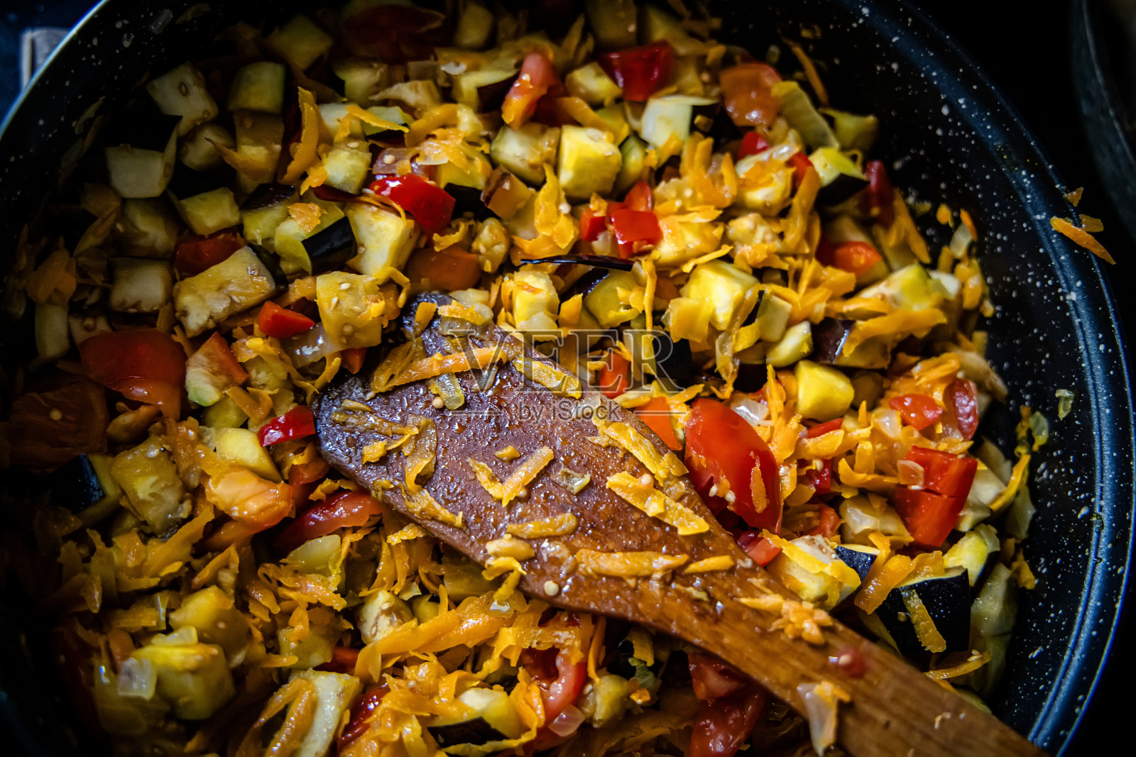 炉上厨师的平底锅里飘出了炖菜的香味。照片摄影图片