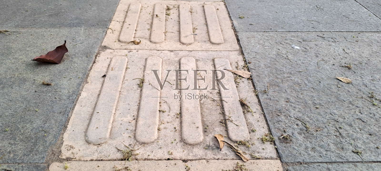 人行道上为视障人士铺设的亮黄色触觉路面。照片摄影图片