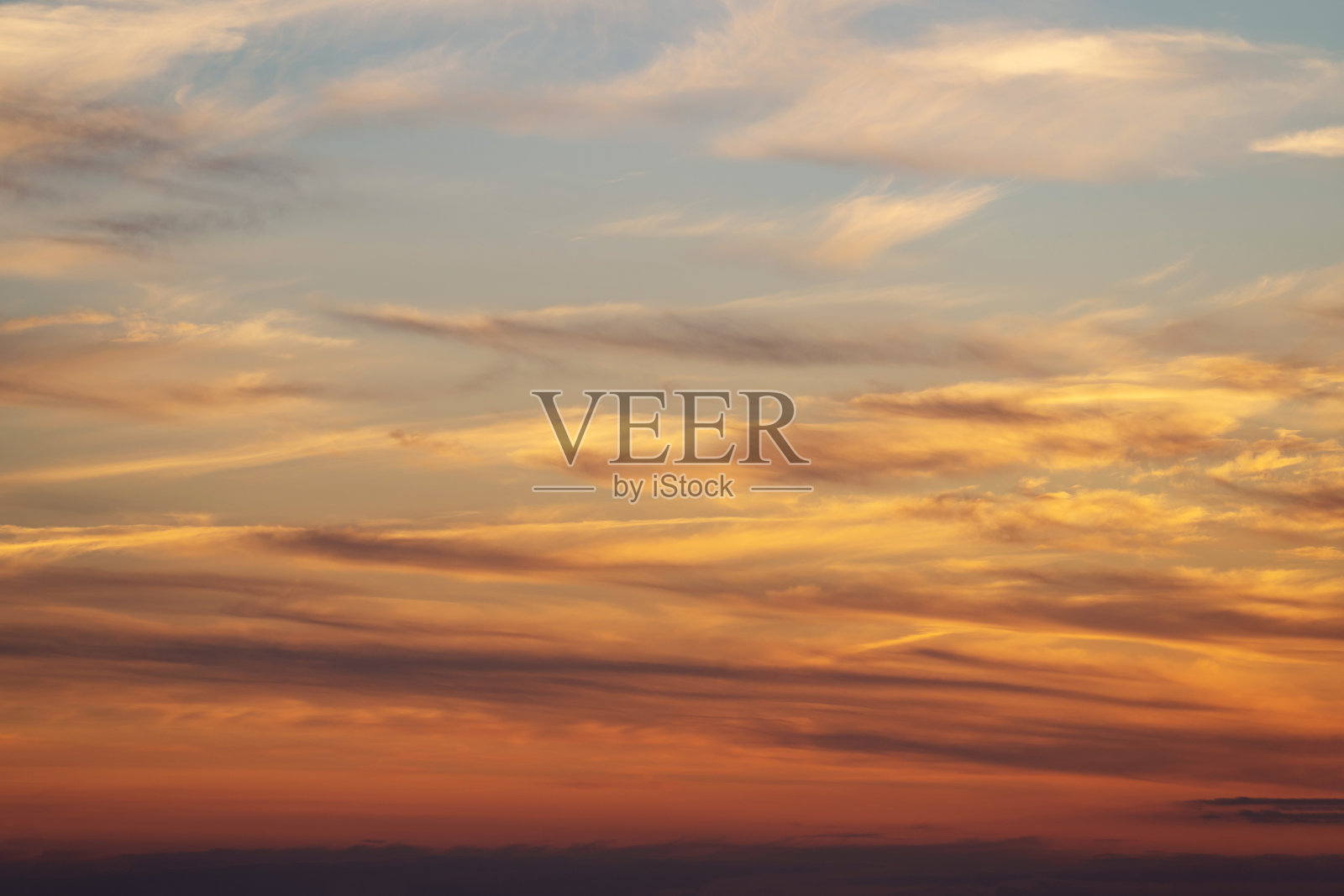 夏日的黄昏，夕阳在黄、橙、粉的白云衬托下照片摄影图片