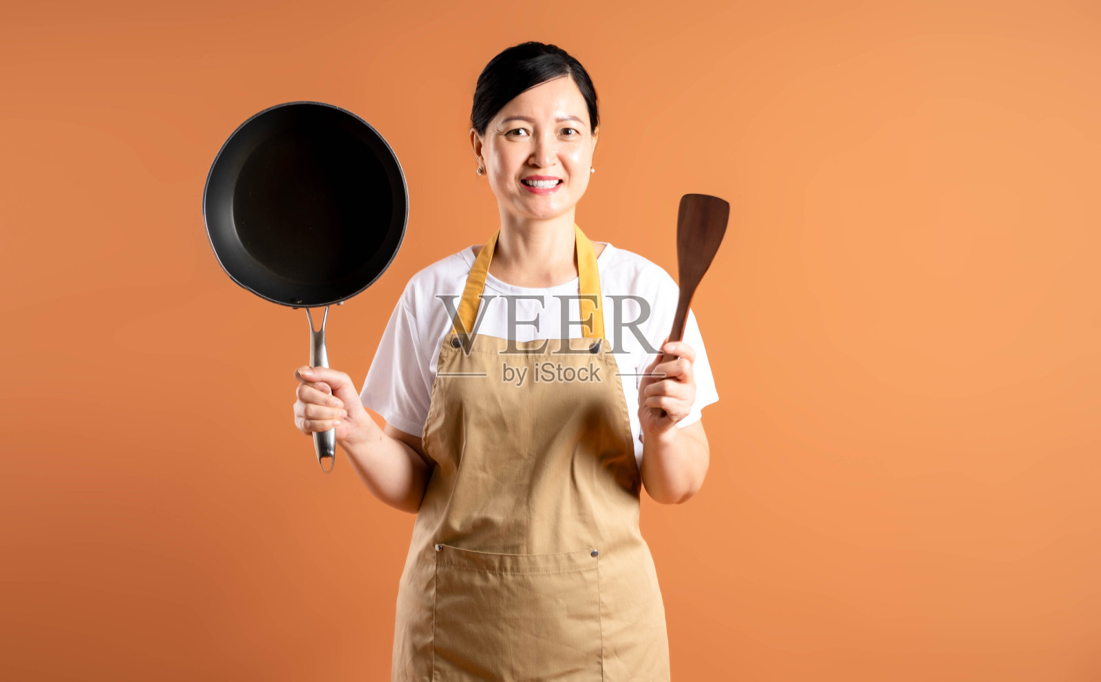 亚洲女性家庭主妇在棕色背景上摆姿势的肖像照片摄影图片