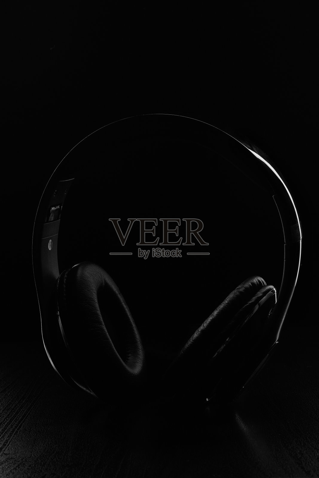 无线入耳式耳机与黑色背景黑色皮革绝缘照片摄影图片