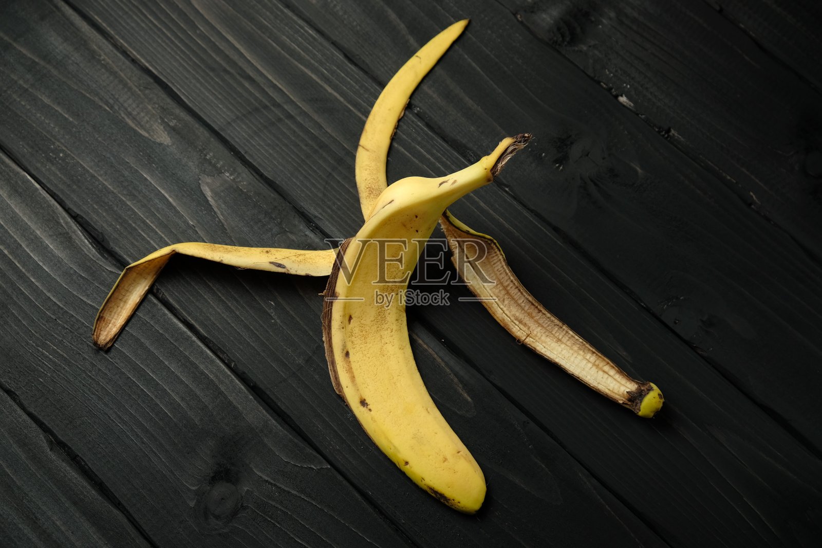 黑色木制背景上的香蕉皮照片摄影图片