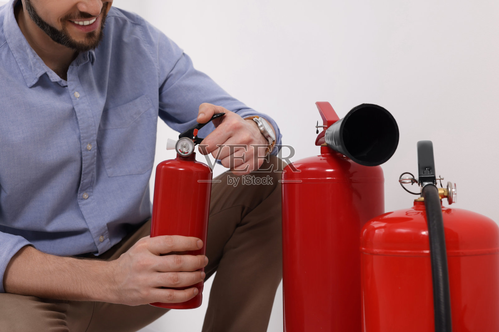检查室内灭火器质量的人员，特写照片摄影图片