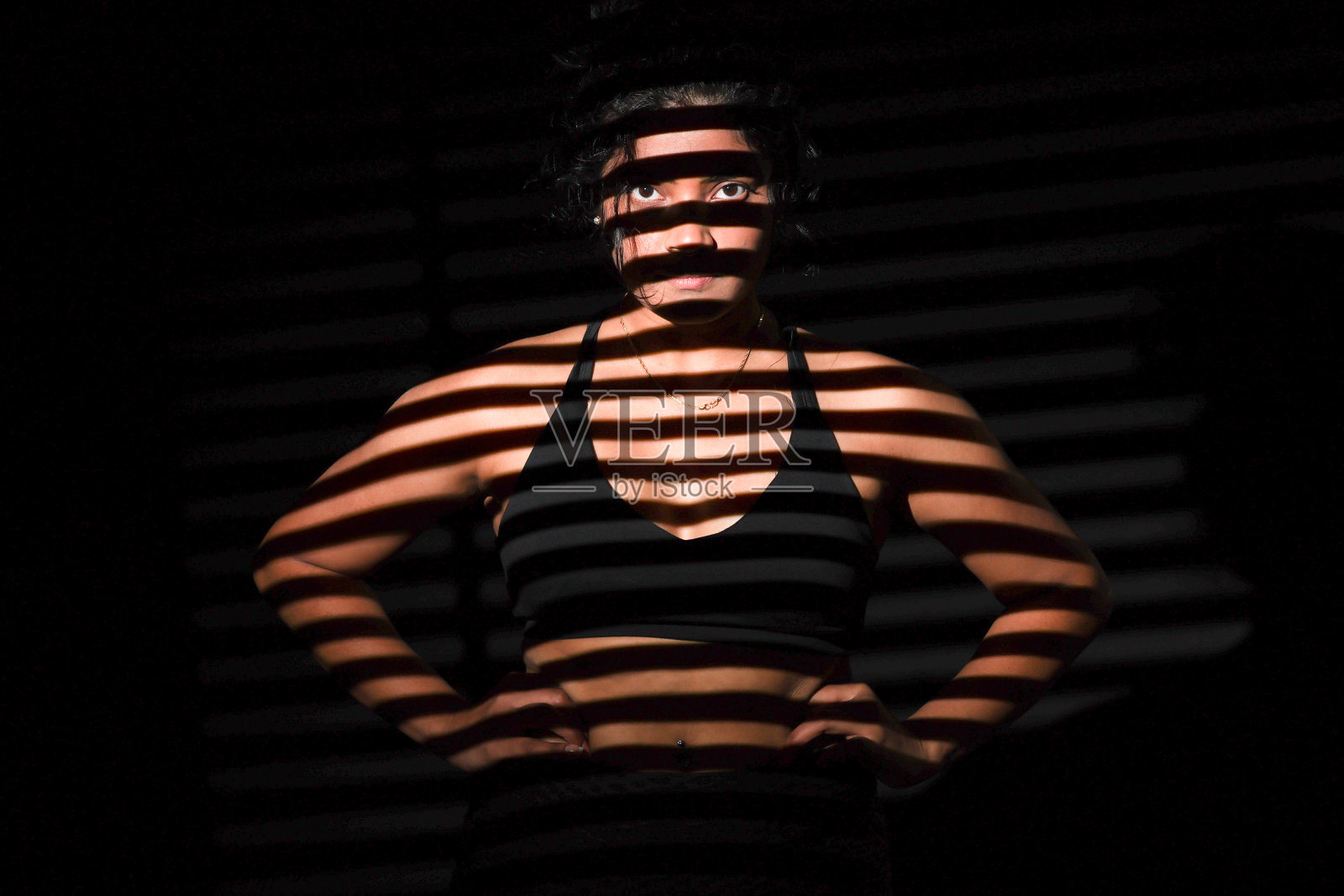 被条纹图案照亮的年轻女子照片摄影图片