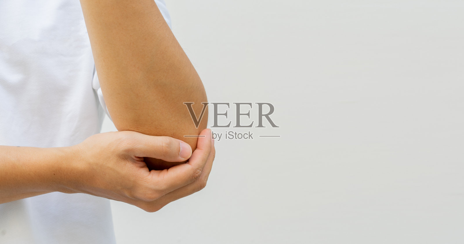 近距离拍摄年轻运动员在运动受伤后用手按摩肘部，以了解健康和生活方式的概念照片摄影图片