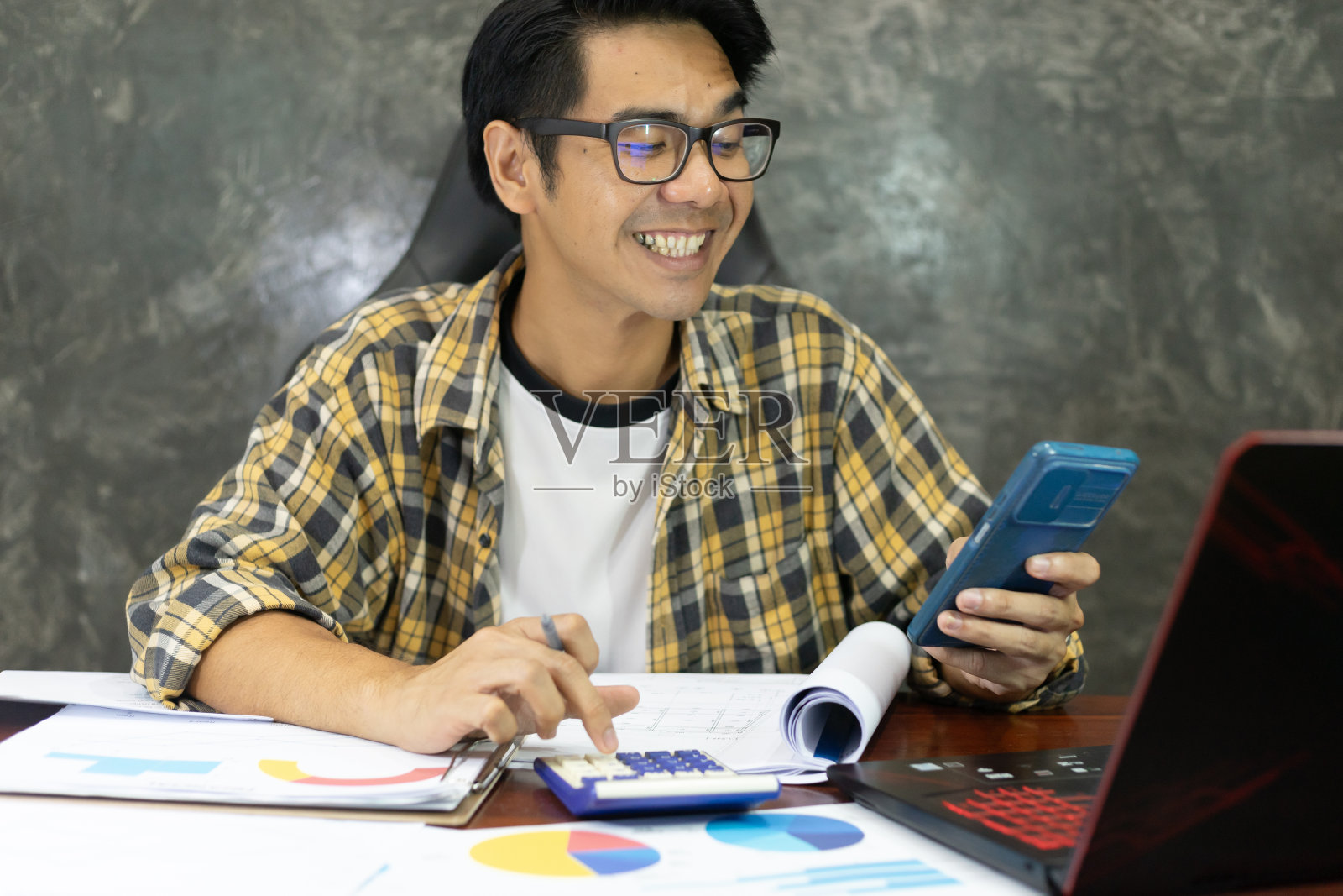 年轻的亚洲企业家在家为金融报纸工作。经营一家初创公司的商人在办公桌旁计算和处理账单发票。照片摄影图片