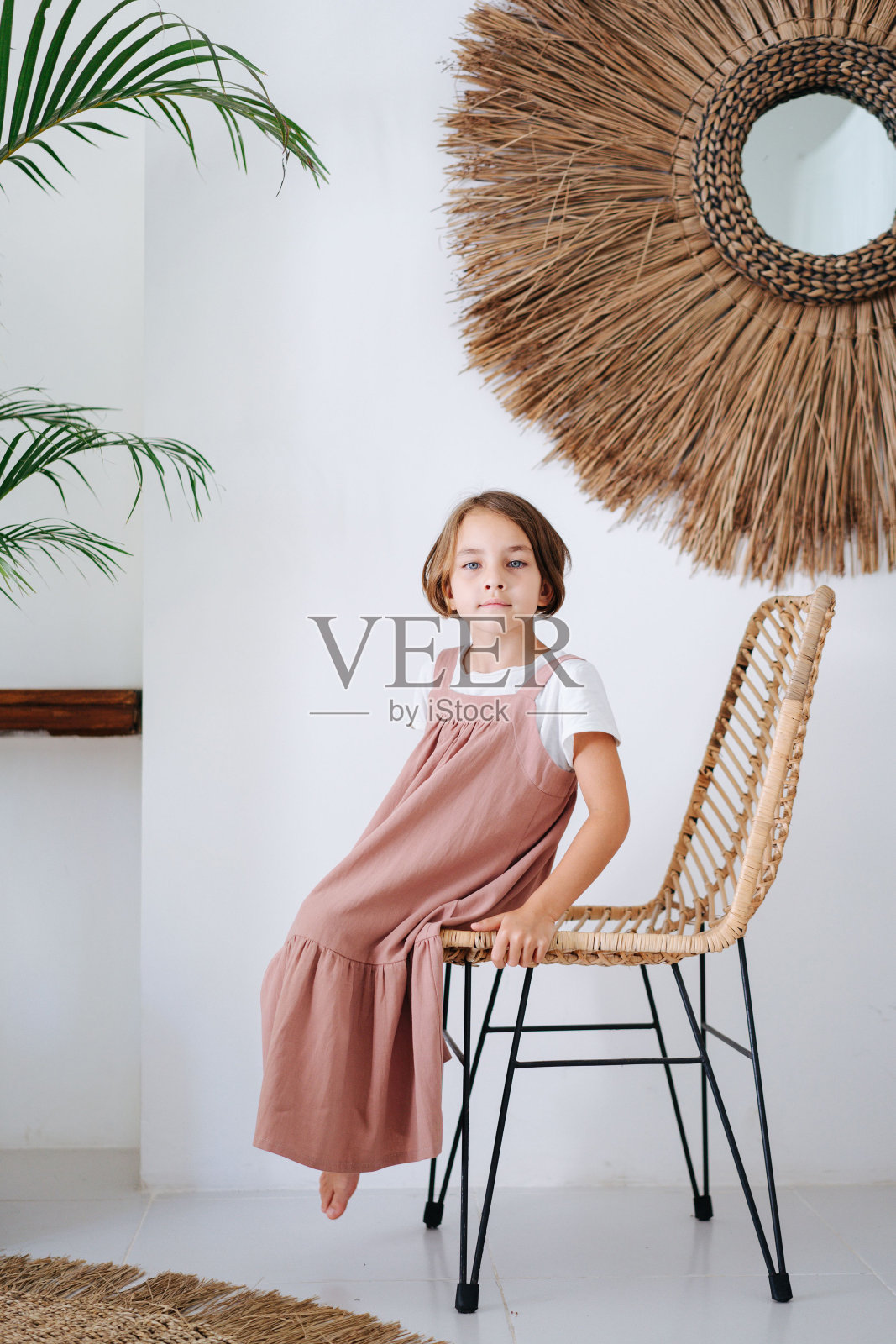 在一个美丽的热带室内，一个女孩坐在椅子上的肖像照片摄影图片