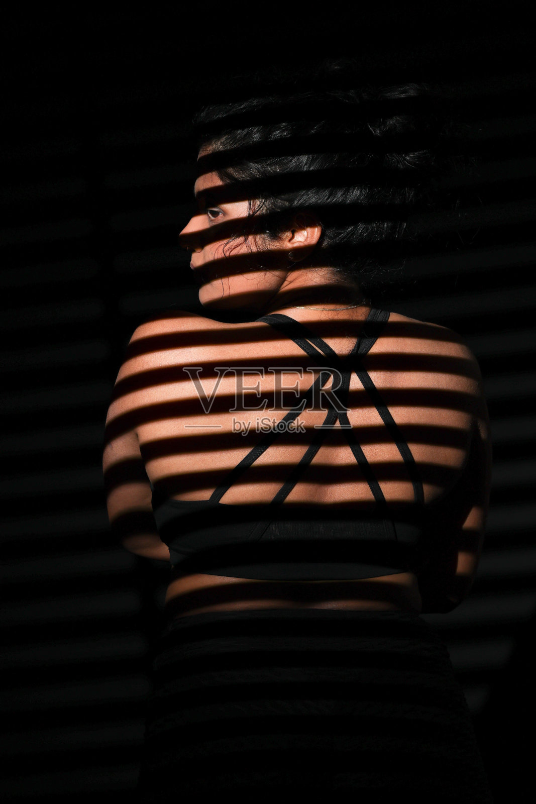 被条纹图案照亮的年轻女子照片摄影图片