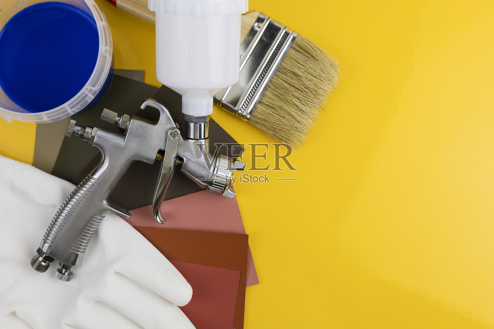 喷漆枪在车间的工作场所工作。油漆刷照片摄影图片