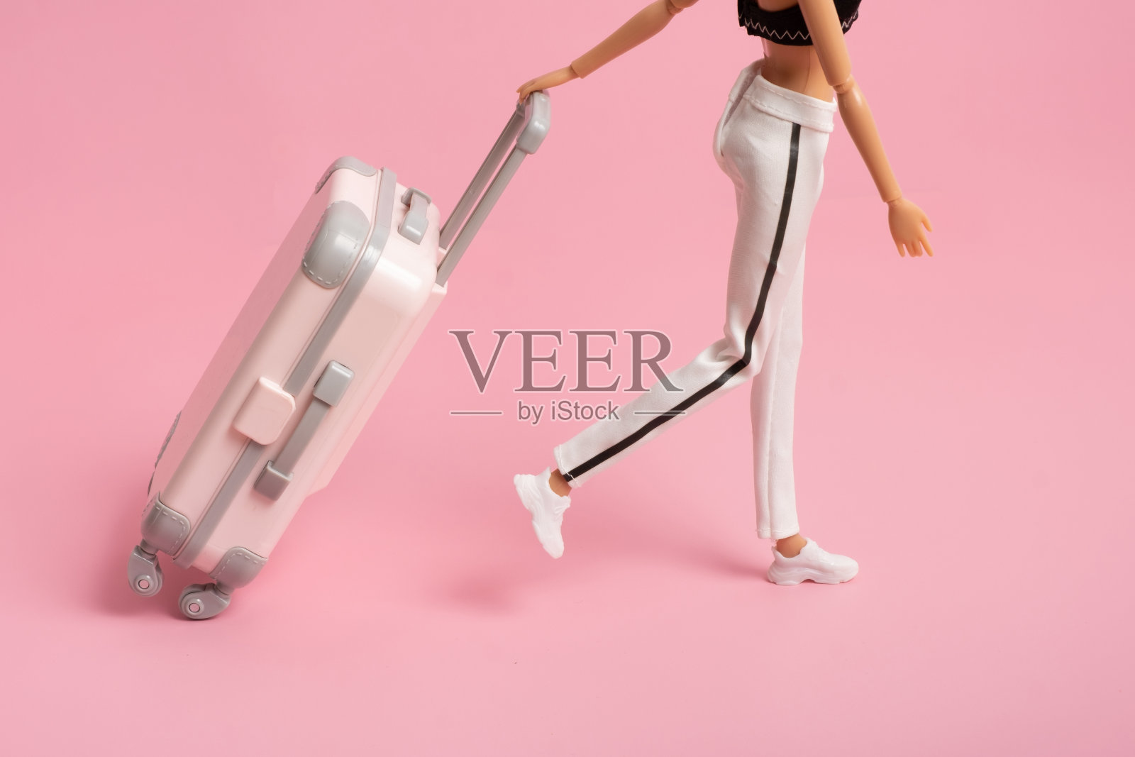 娃娃带着一个带轮子的手提箱。旅游、度假创意极简理念照片摄影图片
