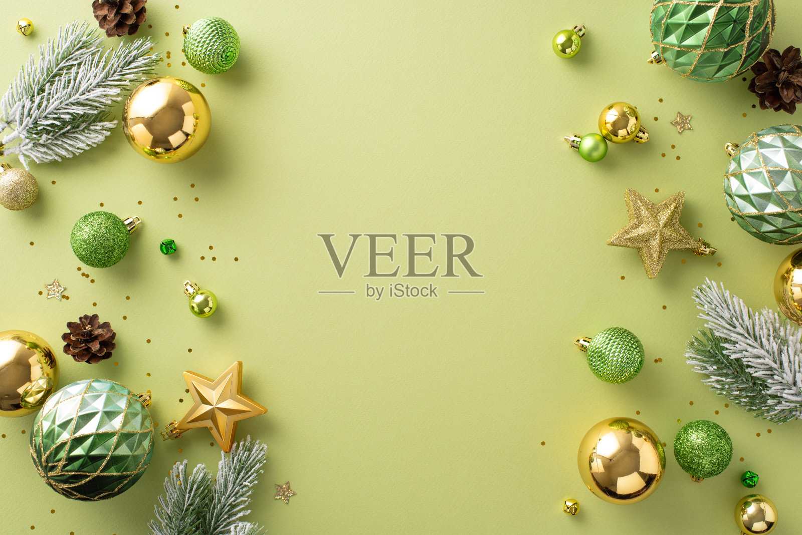 唤起节日的欢乐。头顶上的照片有闪闪发光的树饰品，金色和绿色的小装饰品，灿烂的星星，闪烁的亮片，磨砂松枝在柔和的绿色背景问候或宣传照片摄影图片