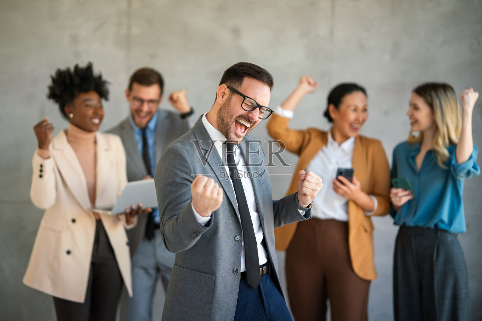 兴奋雀跃的多元企业人士，团队在办公室一起庆祝企业胜利照片摄影图片