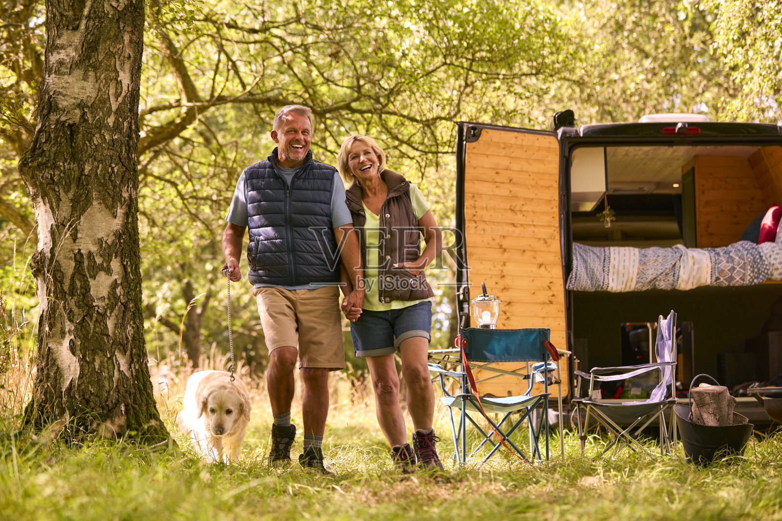 在乡村露营的老年夫妇带着拉布拉多狗散步照片摄影图片