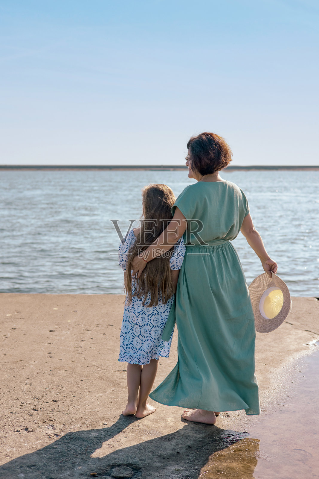 奶奶和她的小孙女在沙滩上微笑着玩耍。和孙女一起度过的周末照片摄影图片