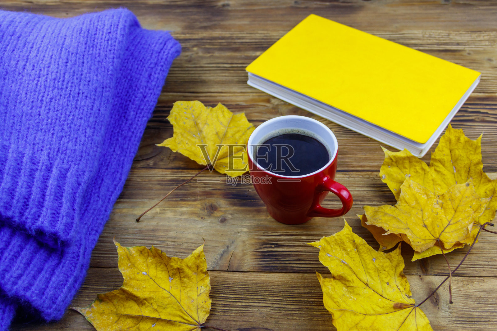 舒适的蓝毛衣、书、咖啡和木桌上的秋日枫叶。秋季舒适概念照片摄影图片