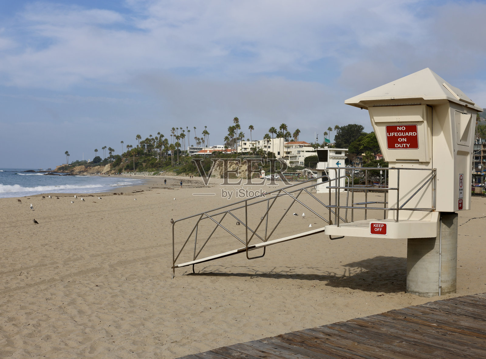夏季人群散去后，救生员站在那里俯瞰空荡荡的海滩照片摄影图片