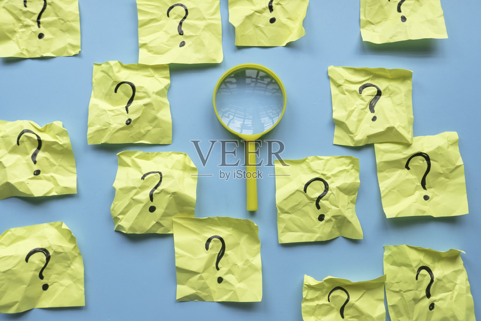 QnA或问答概念。黄色放大镜，在蓝色背景的备忘录上有疑问符号。照片摄影图片