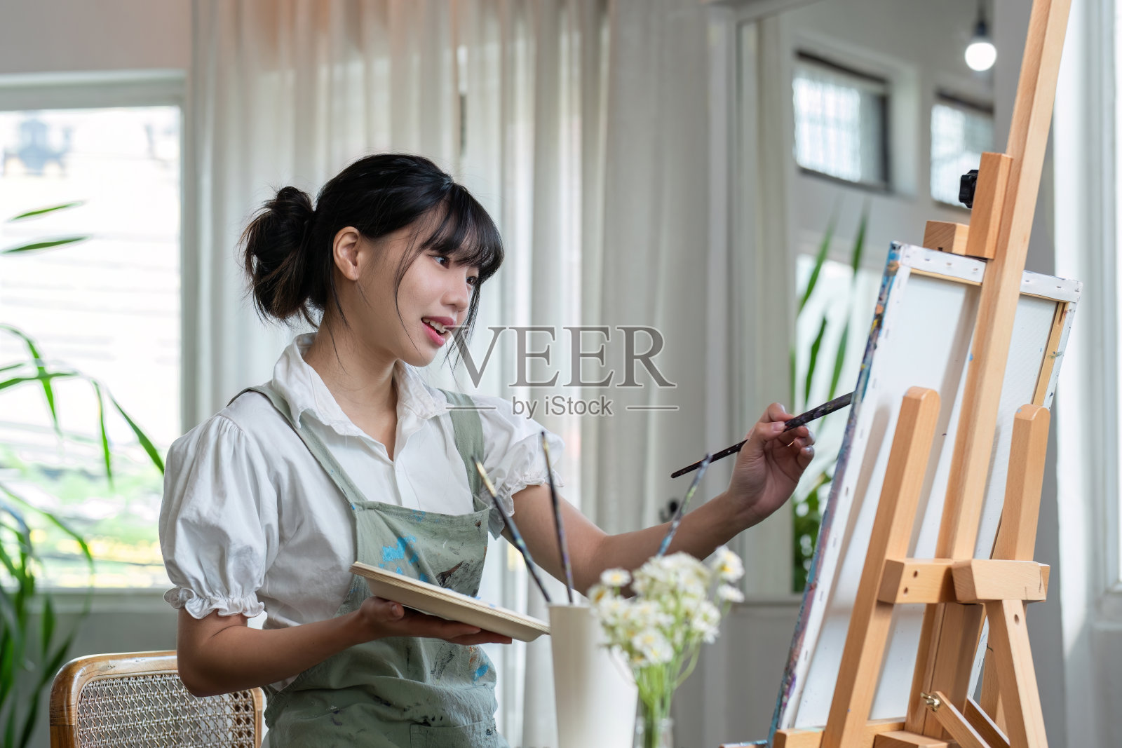 年轻的女艺术家在艺术绘画工作室创作抽象丙烯油画。照片摄影图片