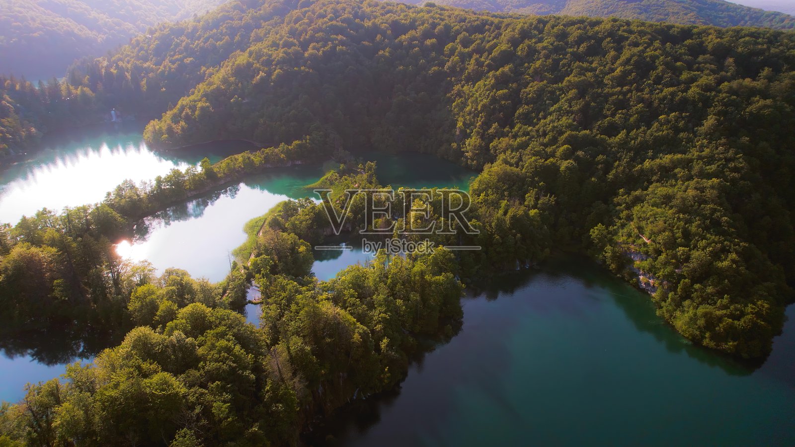 高山中有深蓝湖泊的针叶林。茂密的树木景观在夏季到初秋阳光明媚的早晨。清澈、新鲜、湛蓝的海水。照片摄影图片