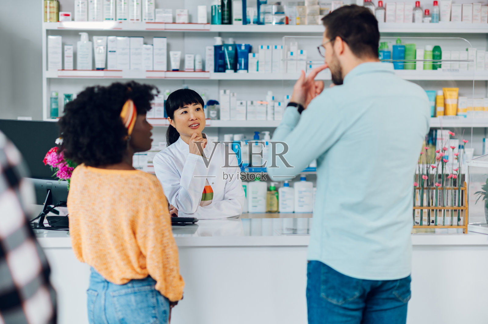 日本女药剂师在药店向形形色色的顾客推销药品照片摄影图片