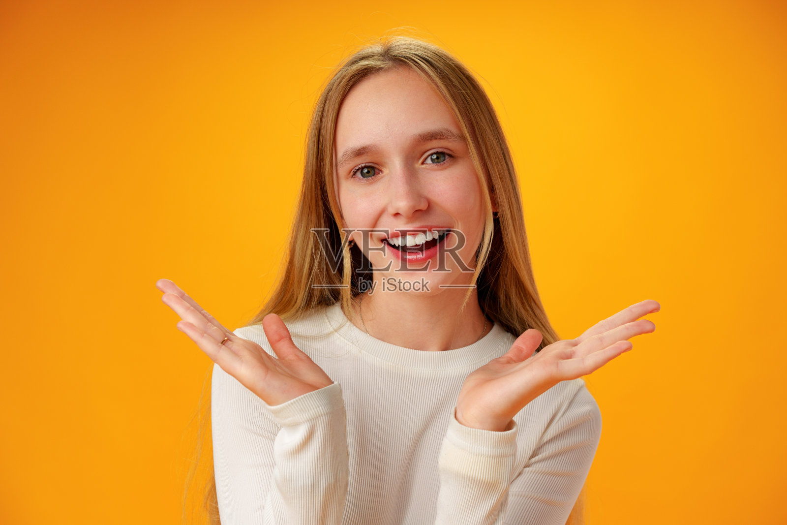 惊讶的十几岁的女孩在工作室的黄色背景照片摄影图片