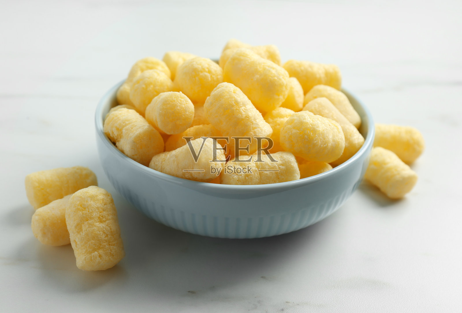 白色大理石桌上的一碗美味脆脆的玉米条照片摄影图片