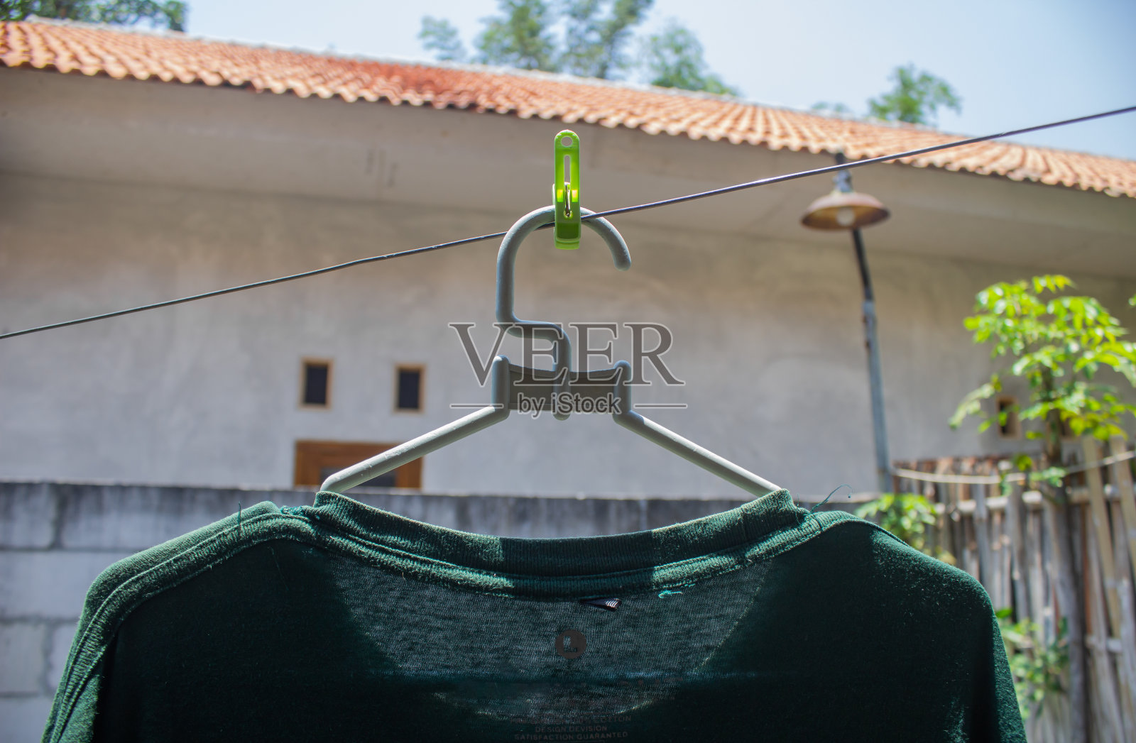 这件深绿色的衬衫是用衣架晒干的照片摄影图片