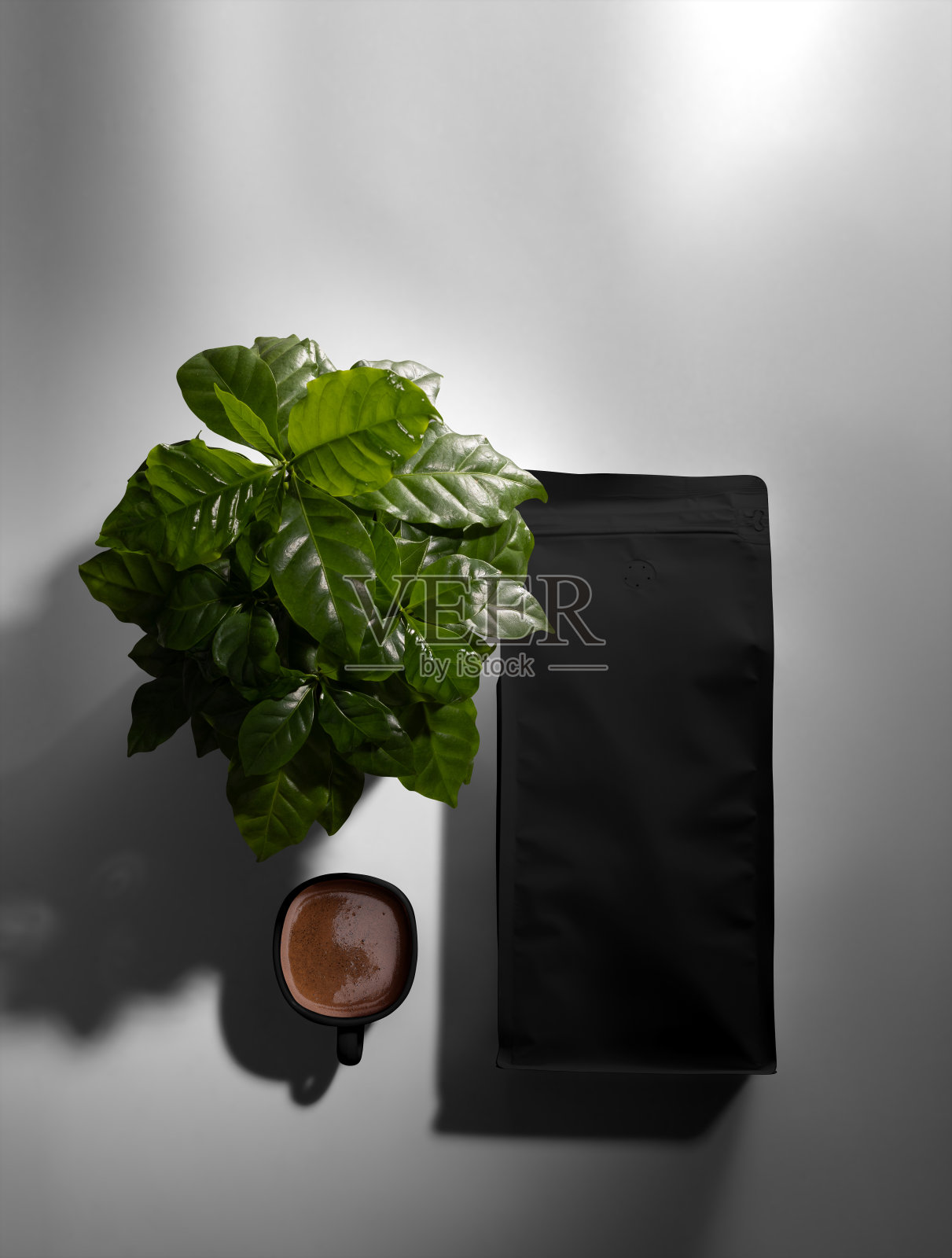 黑色袋模板，俯视图，与一杯煮咖啡，阿拉比卡树，在背景上的阴影。照片摄影图片